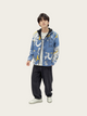 Person wearing a blue patterned jacket on a white background