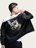 Person wearing a black jacket with floral embroidery on a plain background