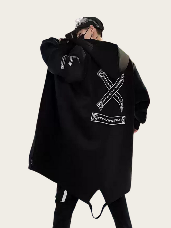 Person wearing a black oversized hoodie with brand logos on a light gray background