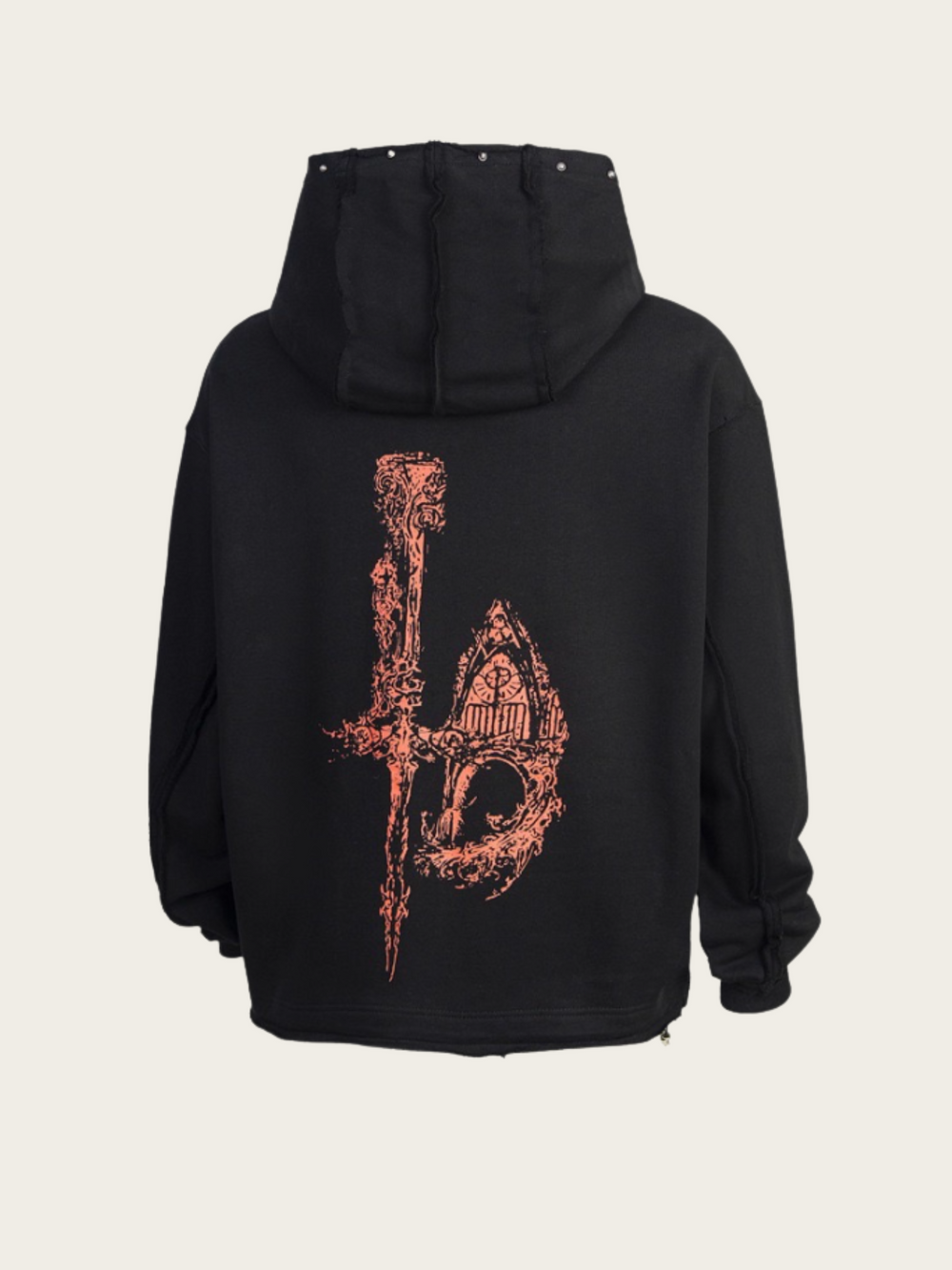 Black hoodie with intricate design on the back against a beige background