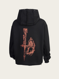 Black hoodie with intricate design on the back against a beige background