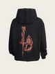 Black hoodie with intricate design on the back against a beige background