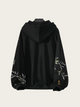 Black hoodie with floral embroidery on a light gray background