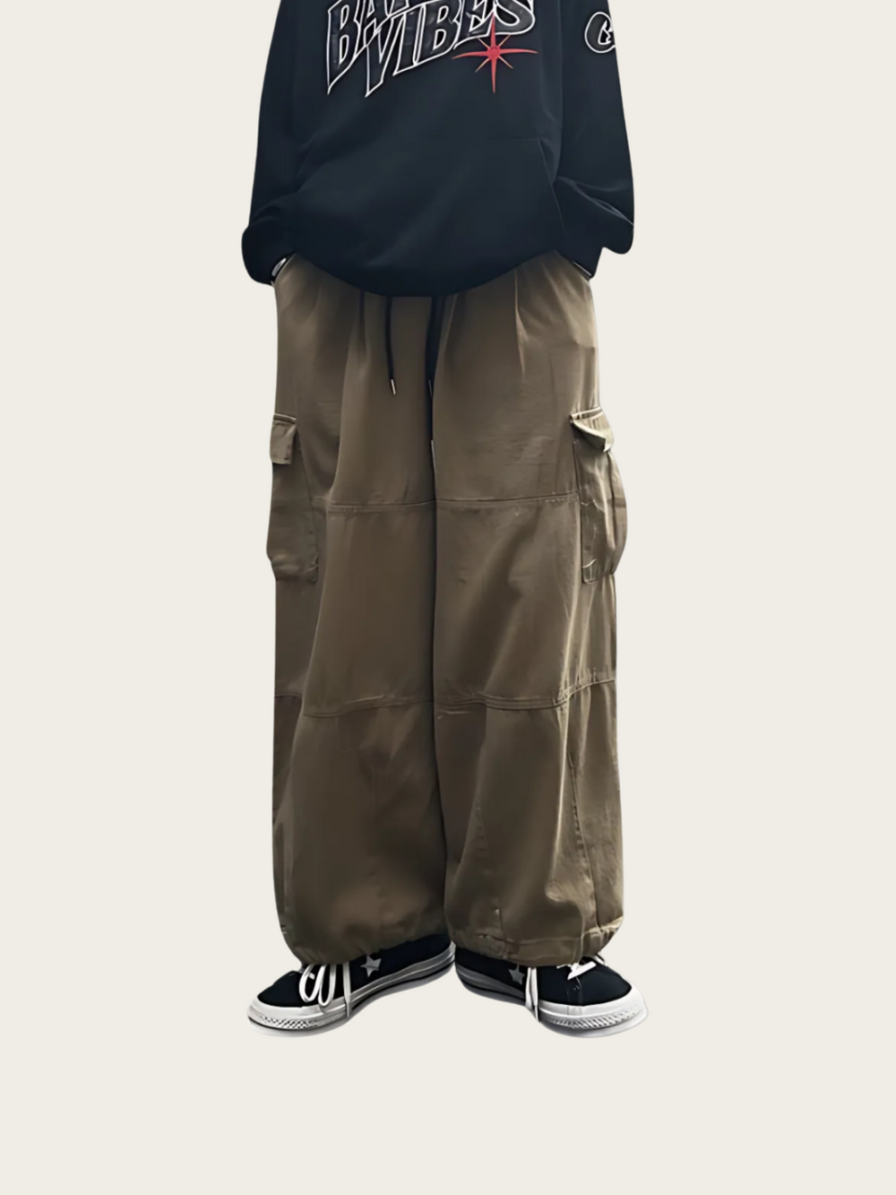 Person wearing a black hoodie with text and brown cargo pants on a white background