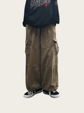 Person wearing a black hoodie with text and brown cargo pants on a white background