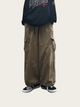 Person wearing a black hoodie with text and brown cargo pants on a white background