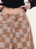 Brown and beige checkered pants worn by a person on a plain background