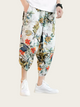 Person wearing floral print pants on a plain background