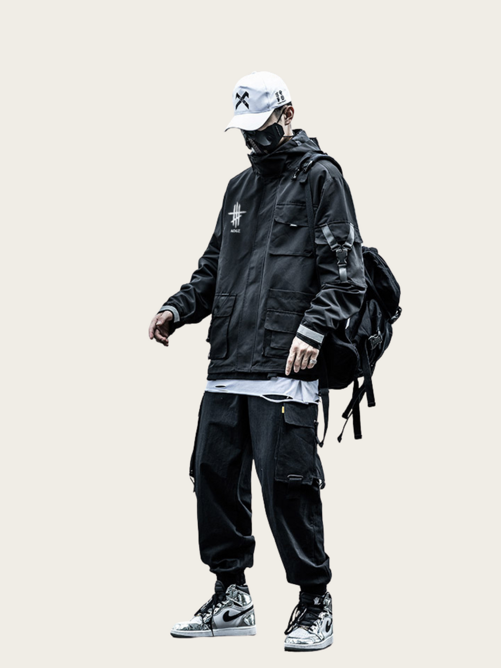Person wearing a black jacket, pants, and sneakers with a backpack on a beige background