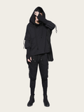 Person wearing a black hoodie and pants on a white background