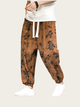 Brown floral-patterned pants worn by a person on a white background