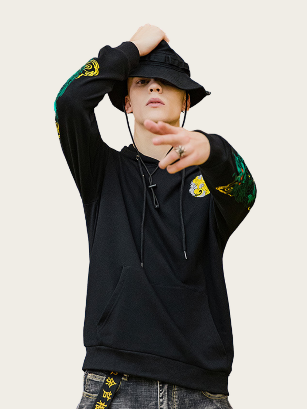 Person wearing a black hoodie with colorful designs on sleeves against a white background