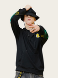 Person wearing a black hoodie with colorful designs on sleeves against a white background