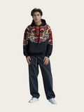 Person wearing a colorful hoodie with a dragon design on a plain background