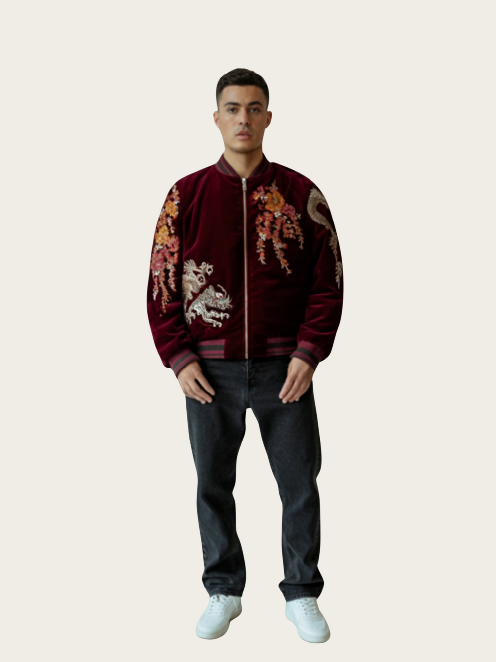 Man wearing a burgundy jacket with floral and dragon designs on a plain background