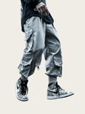 Person wearing gray cargo pants and silver high-top sneakers on a light background