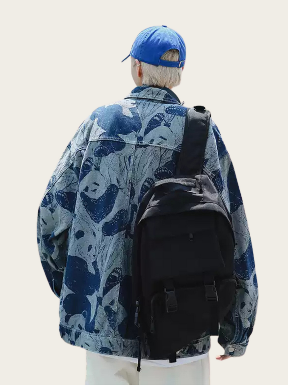 Person wearing a blue cap and patterned jacket with a black backpack on a plain background