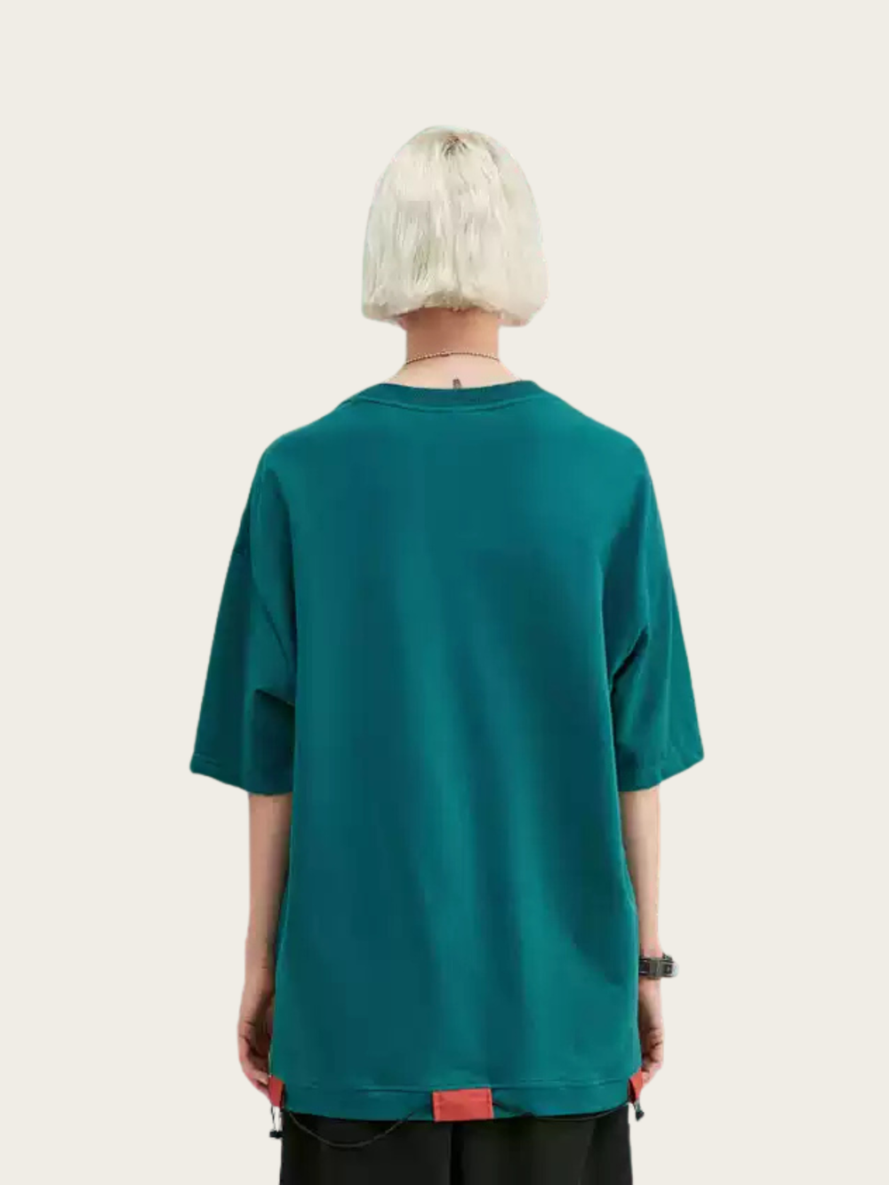Person wearing a teal oversized t-shirt on a plain background