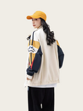 Person wearing a colorful jacket and yellow cap on a white background