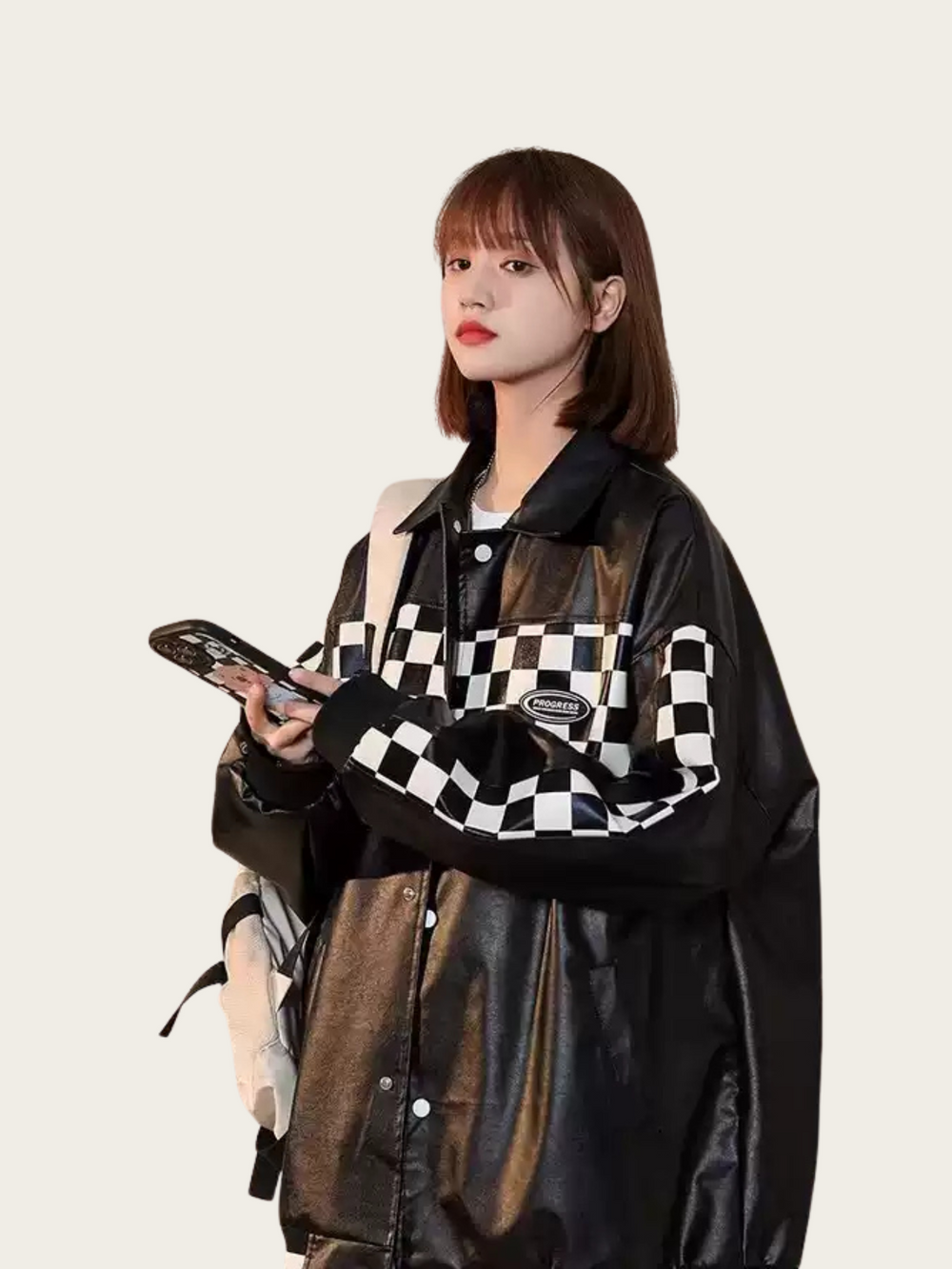 Person wearing a black and white checkered shirt with a brown leather jacket on a plain background