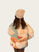Person wearing a patterned jacket with text on a plain background
