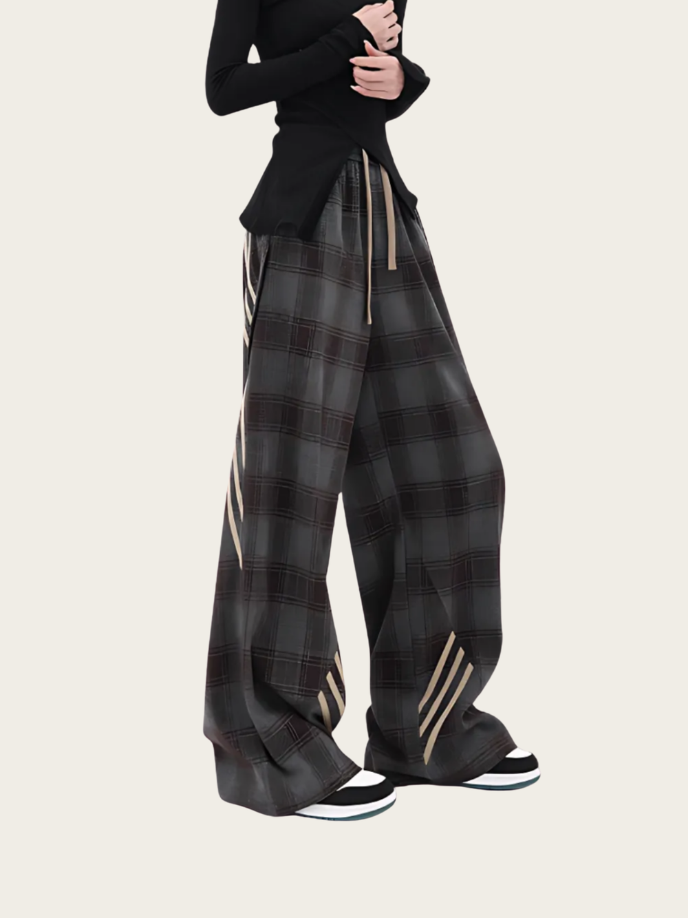 Person wearing black plaid pants with white stripes on a white background