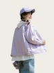Person wearing a light purple jacket and cap on a plain background
