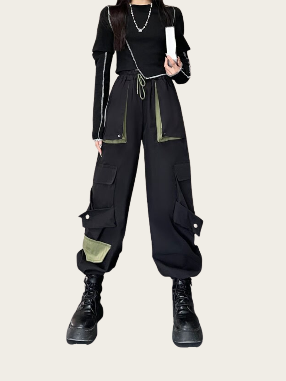 Person wearing a black and green outfit with cargo pants on a white background