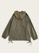 Green jacket with a hood on a beige background