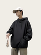 Person wearing a black hoodie and beige cap on a plain background