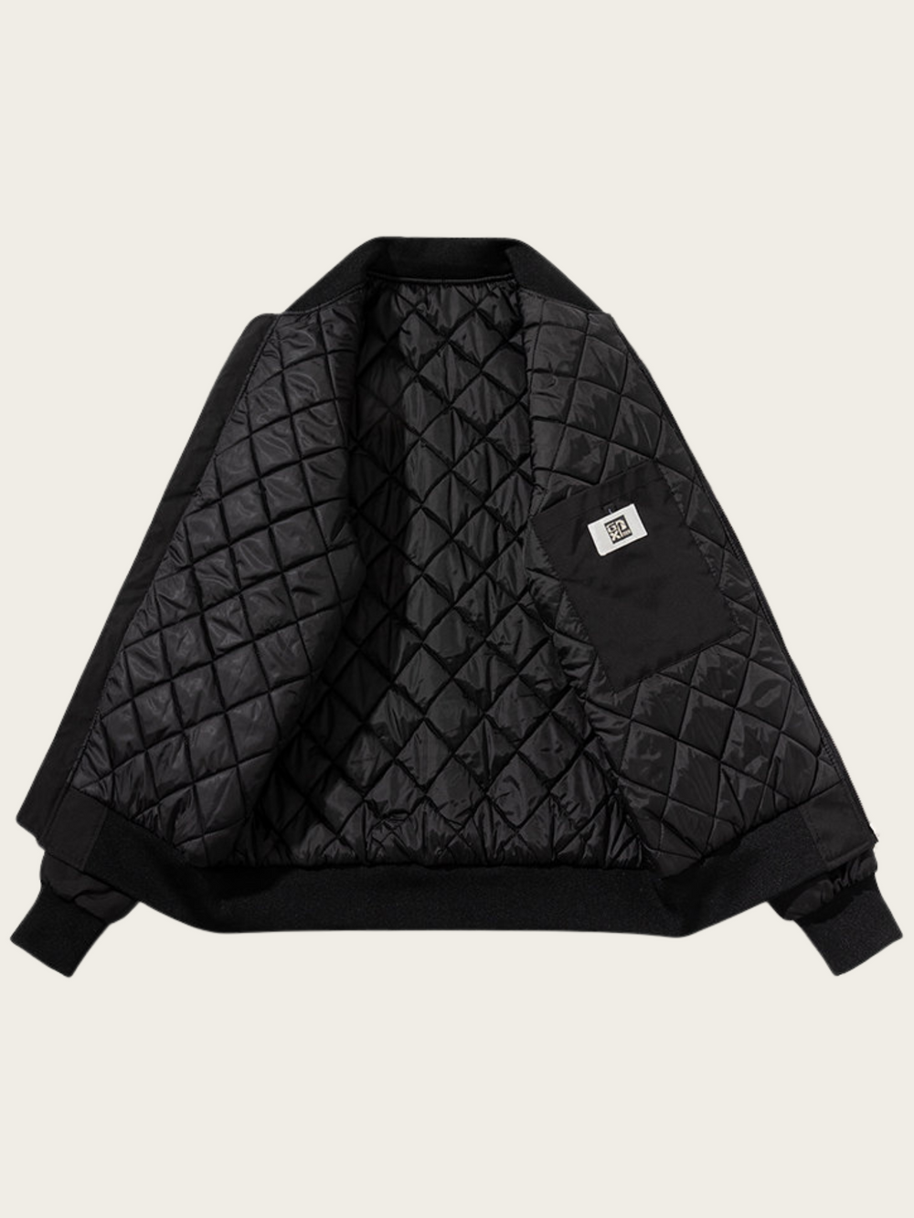 Black quilted jacket on a beige background