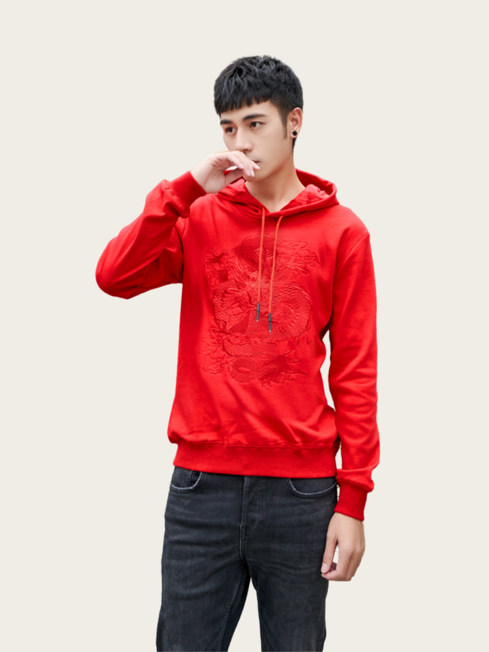 Person wearing a red hoodie with a brand logo on a plain background