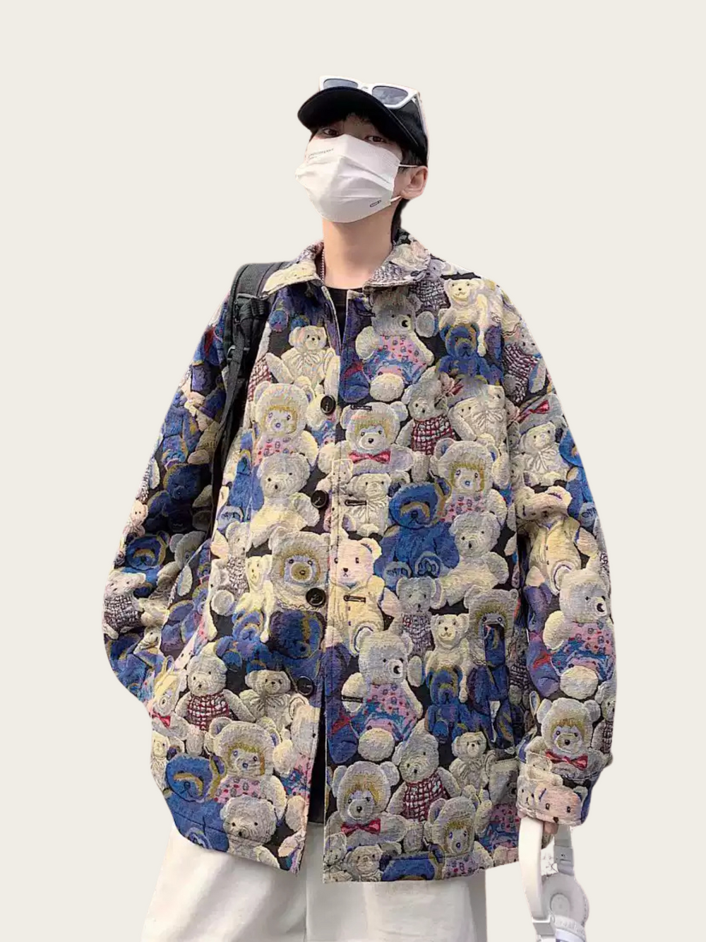 Person wearing a colorful teddy bear patterned coat on a white background