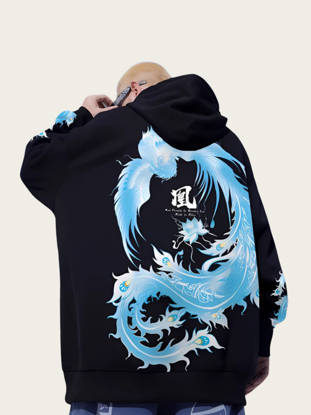Person wearing a black hoodie with a blue and white dragon design on the back.