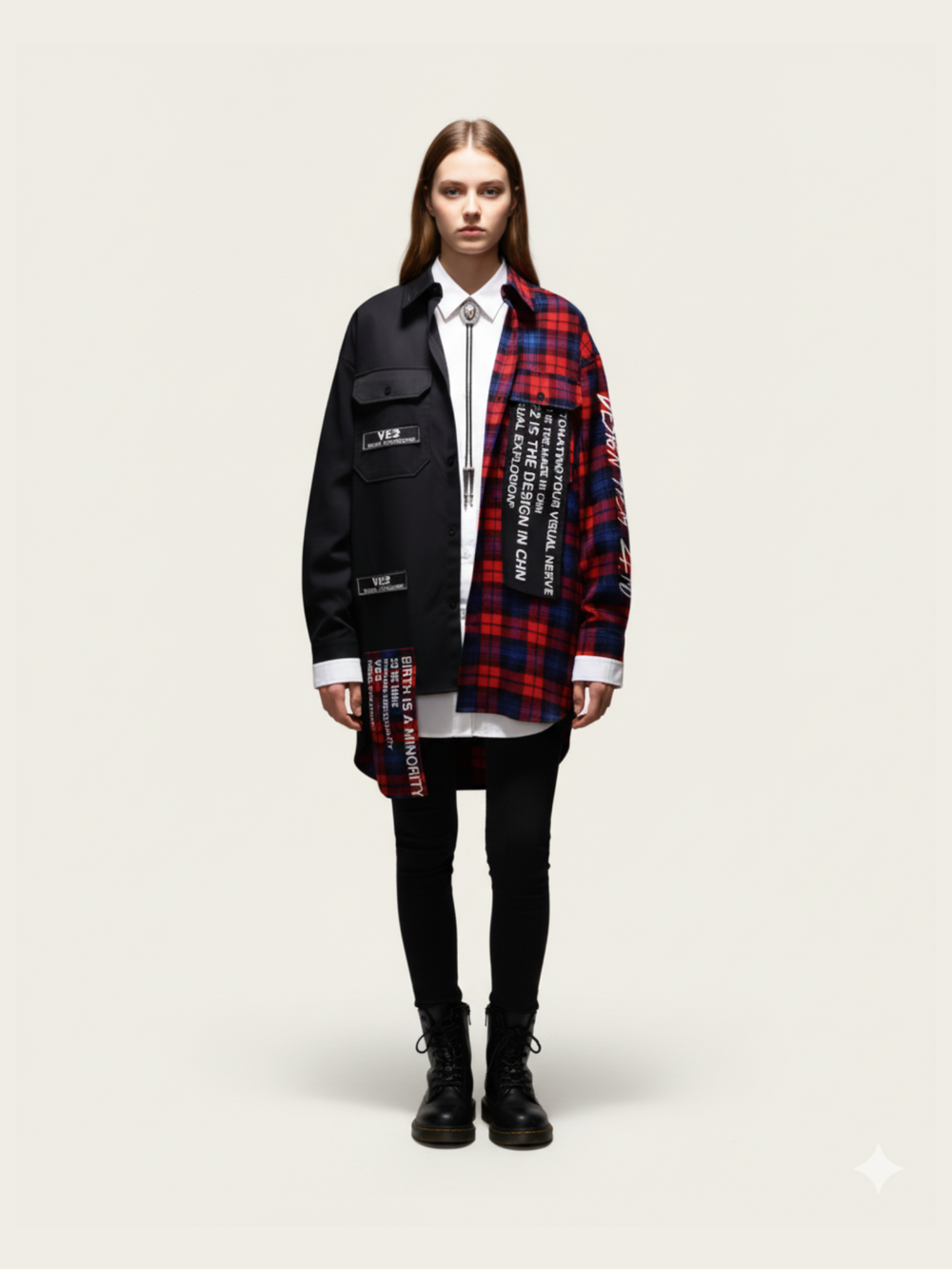 Person wearing a black jacket with text and a red plaid scarf on a white background