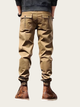 Person wearing beige cargo pants and brown boots on a white background