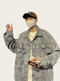 Person wearing a patterned jacket and cap, holding a box of cigarettes.