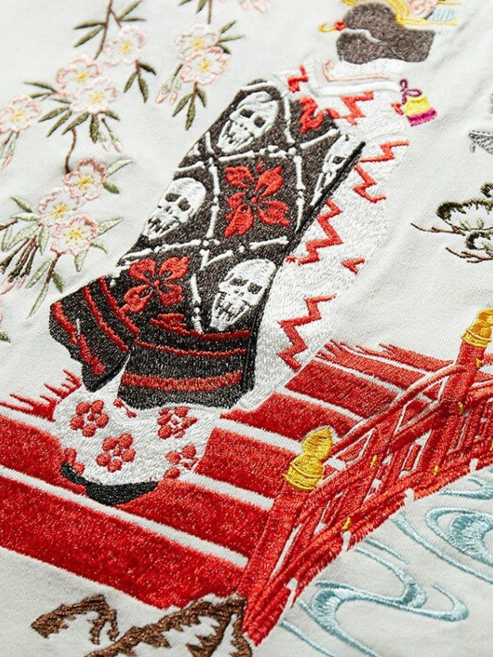 Embroidered design of a red bridge with floral patterns on a white background