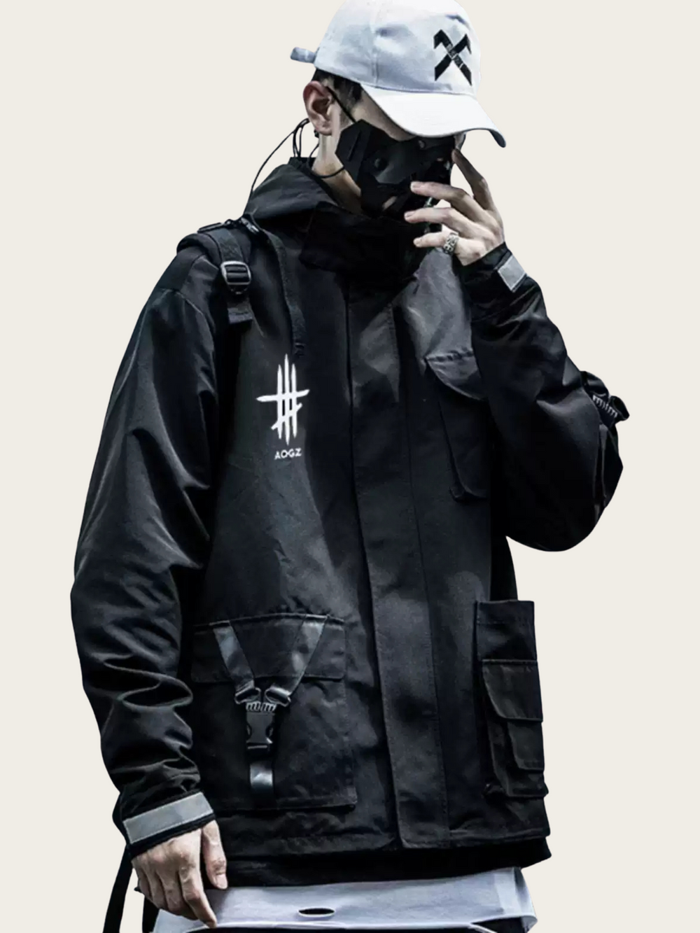 Person wearing a black jacket with a logo, white cap, and backpack on a light background