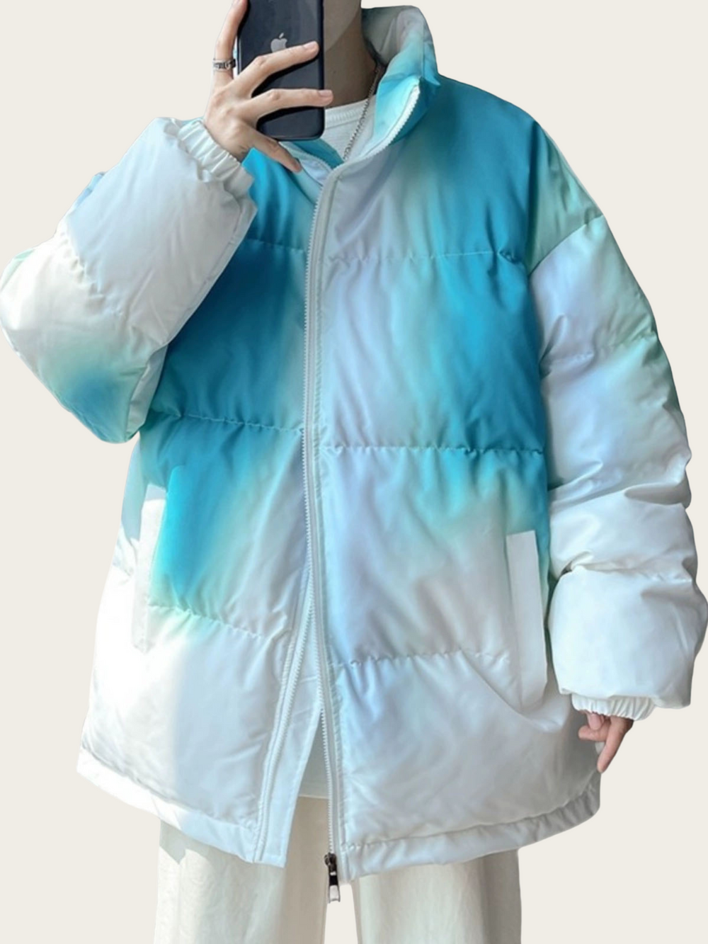 White and blue gradient puffer jacket worn by a person against a plain background