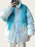 White and blue gradient puffer jacket worn by a person against a plain background