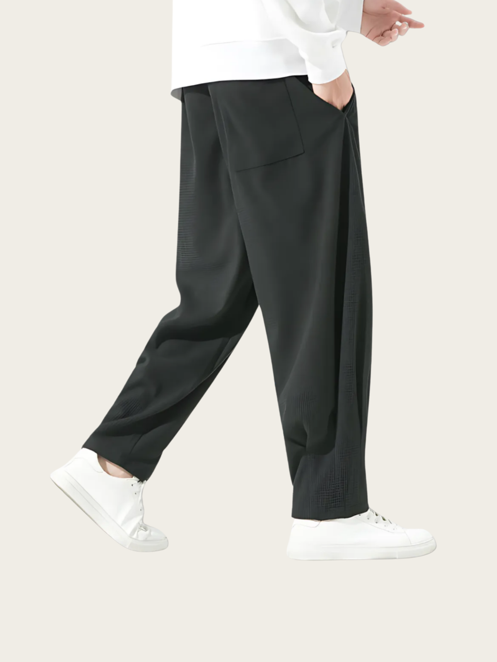 Person wearing black pants and white shoes on a plain background