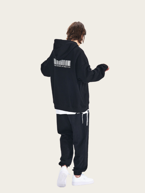 Person wearing a black hoodie and pants with a barcode design on the back, standing against a white background.