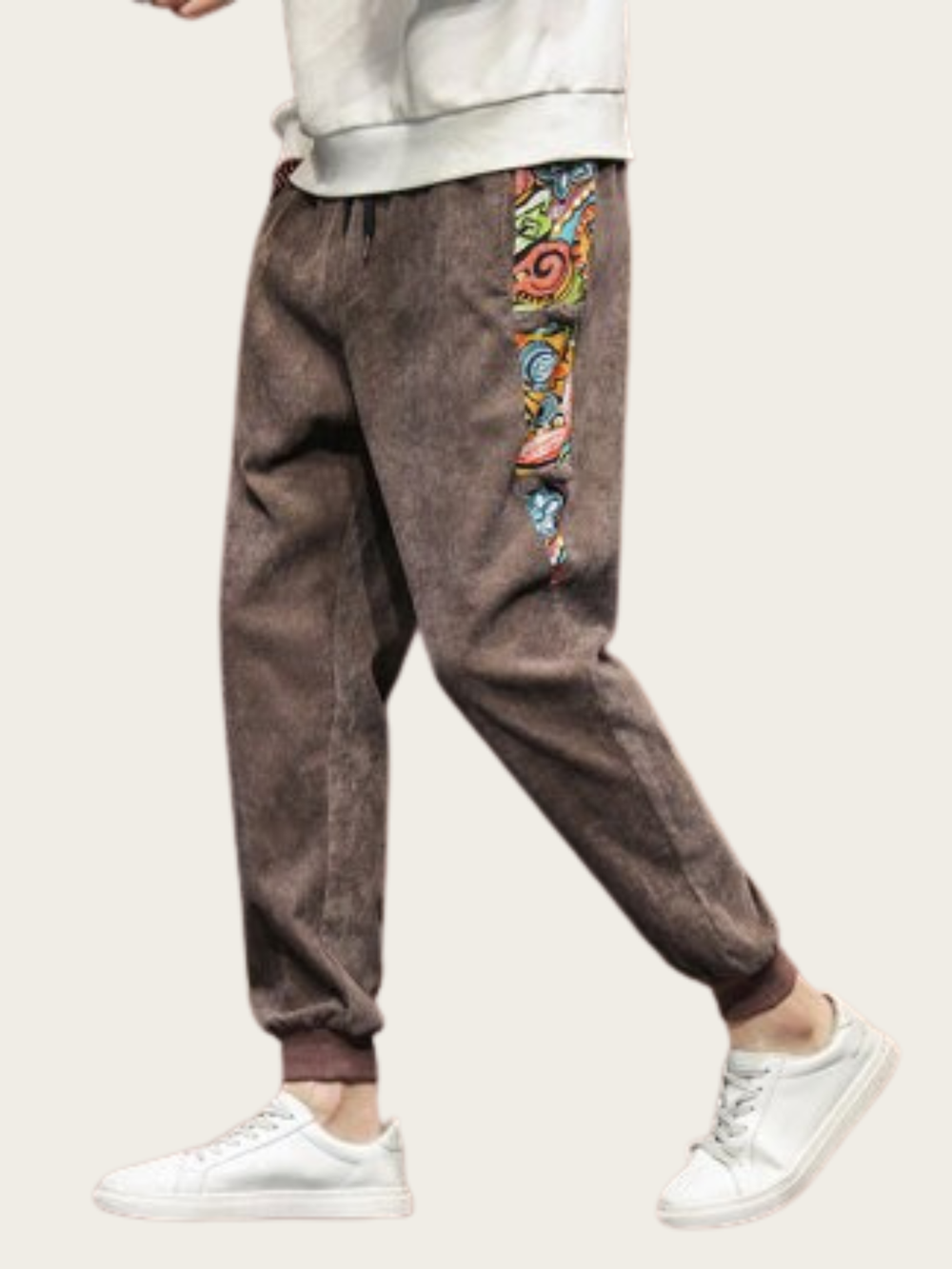 Brown pants with colorful side panels worn by a person on a white background