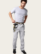 Man wearing light gray pants with tool belt on a white background