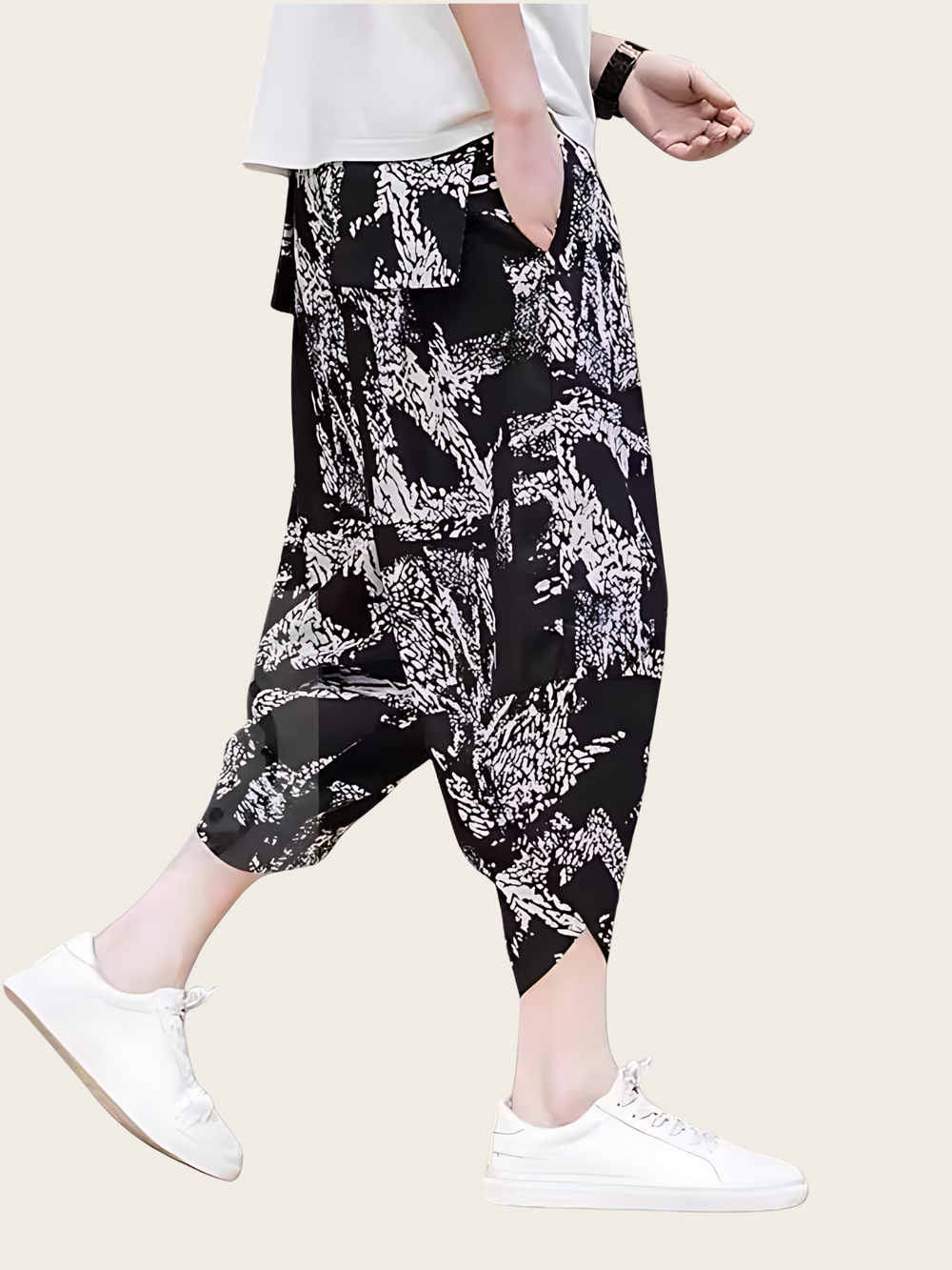 Person wearing black and white patterned harem pants on a white background