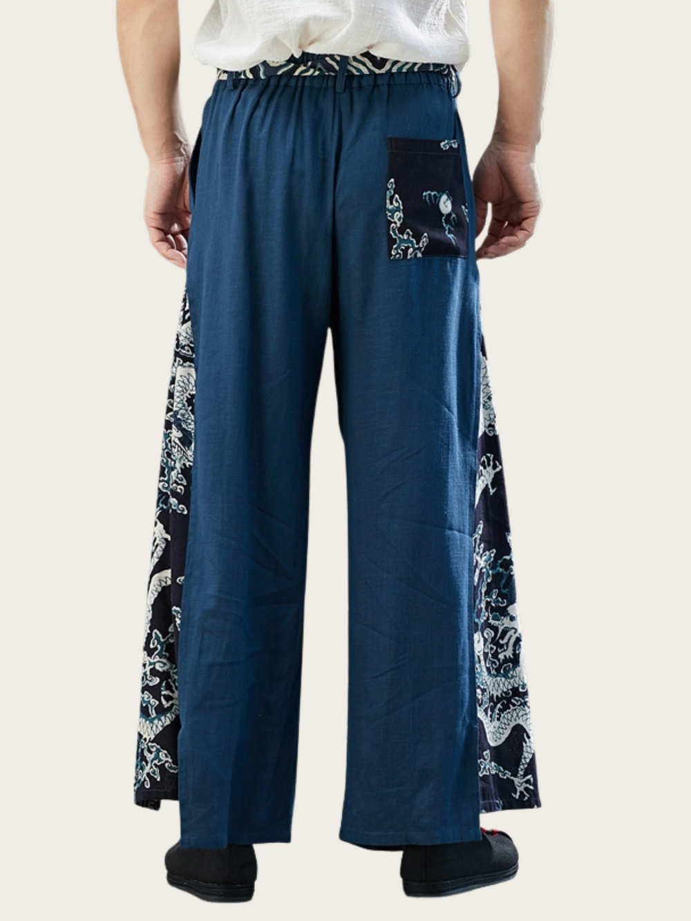 Blue wide-leg pants with white floral patterns on a beige background