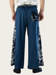Blue wide-leg pants with white floral patterns on a beige background