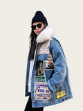 Person wearing a denim jacket with patches on a white background