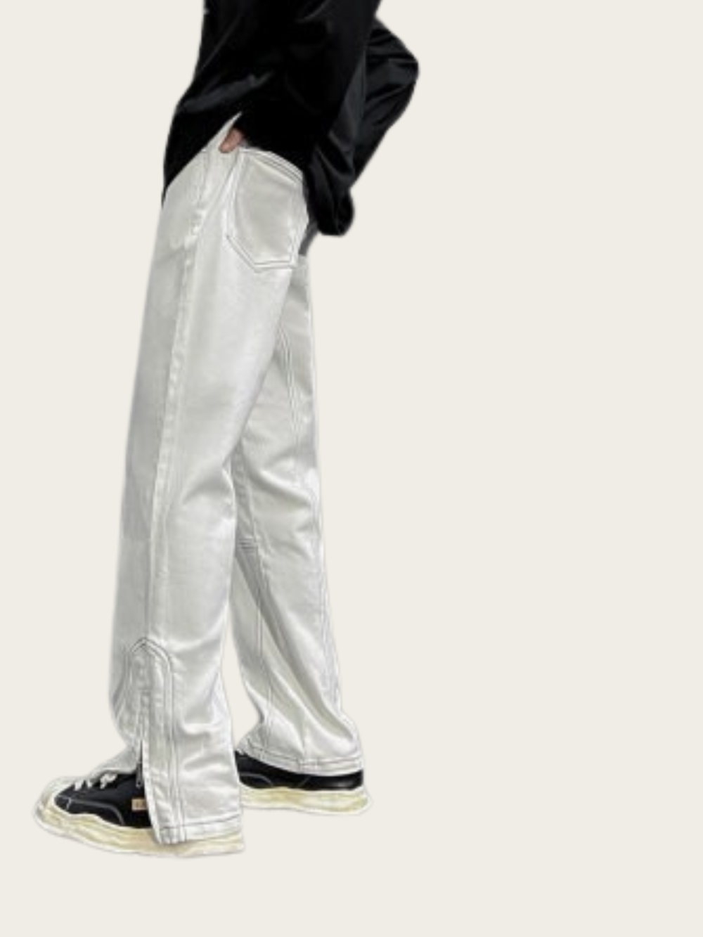 Person wearing silver reflective pants on a white background